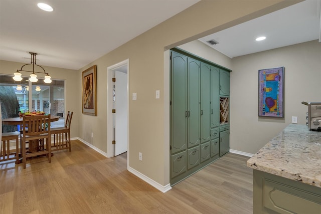 interior space featuring visible vents, baseboards, light wood-type flooring, recessed lighting, and green cabinets