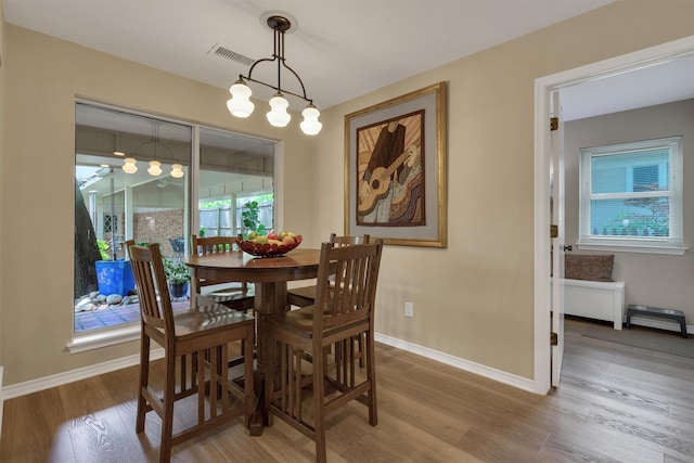 dining space with visible vents, baseboards, and wood finished floors