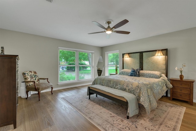 bedroom featuring baseboards, ceiling fan, and light wood finished floors