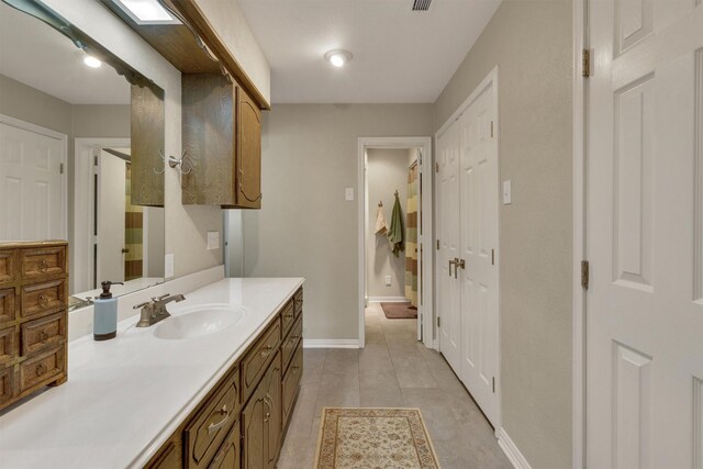 bathroom featuring baseboards, vanity, and tile patterned floors
