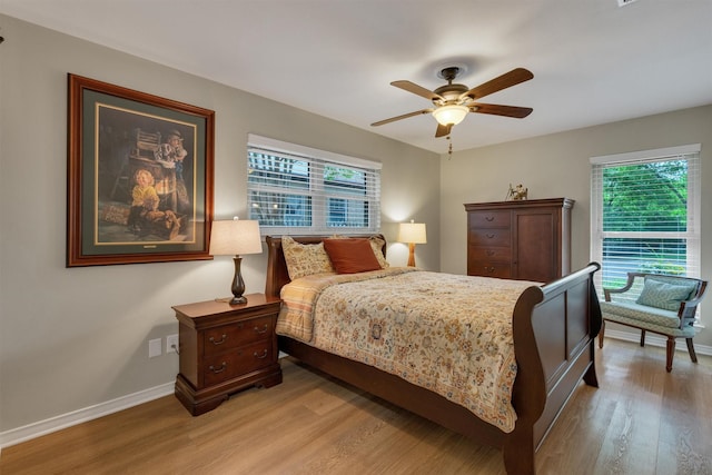 bedroom with light wood-style floors, baseboards, and multiple windows