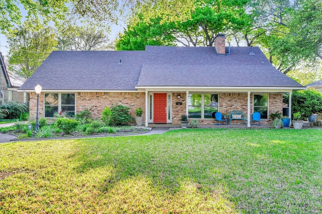 single story home with a shingled roof, a chimney, a front lawn, and brick siding
