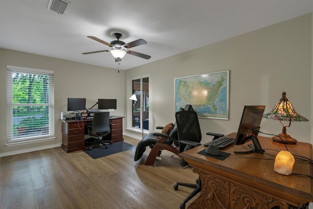 office space featuring visible vents, light wood finished floors, ceiling fan, and baseboards