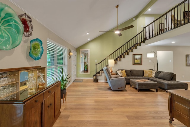 living area featuring light wood-style floors, recessed lighting, high vaulted ceiling, and stairway