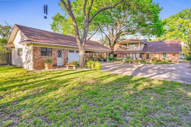 view of front of home with brick siding, driveway, and a front lawn