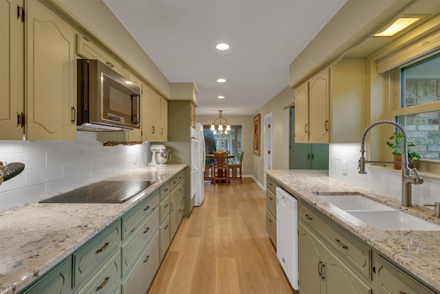 kitchen featuring white appliances, recessed lighting, a sink, light wood finished floors, and backsplash