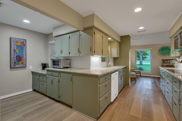 kitchen with baseboards, a sink, light wood-style flooring, and white dishwasher