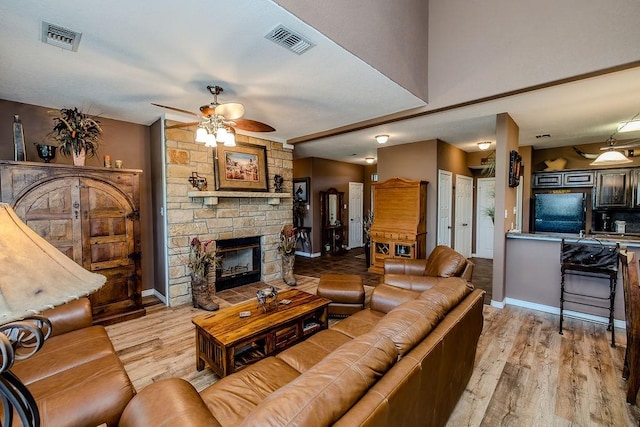 living area featuring a ceiling fan, visible vents, and light wood-type flooring