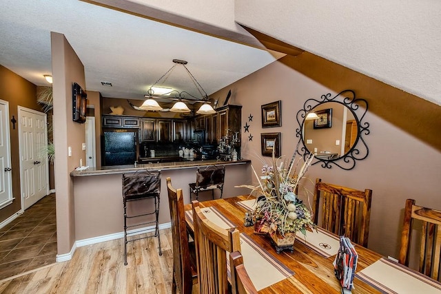 dining space with light wood finished floors and baseboards