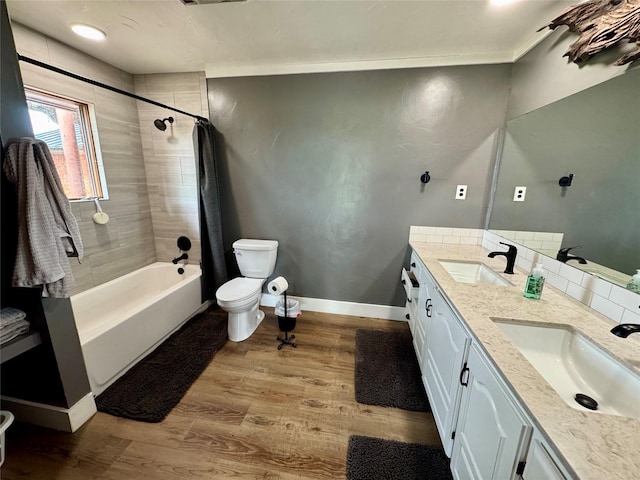 712 State Highway 67, Graham, TX 76450 - bathroom featuring wood finished floors, shower / bath combination with curtain, toilet, and a sink
