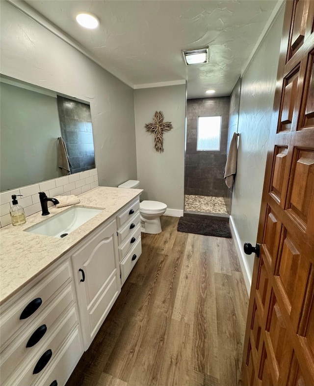 712 State Highway 67, Graham, TX 76450 - full bathroom featuring vanity, tasteful backsplash, toilet, walk in shower, and wood finished floors