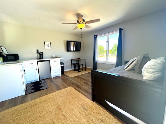 712 State Highway 67, Graham, TX 76450 - bedroom with dark wood finished floors, baseboards, ceiling fan, and fridge
