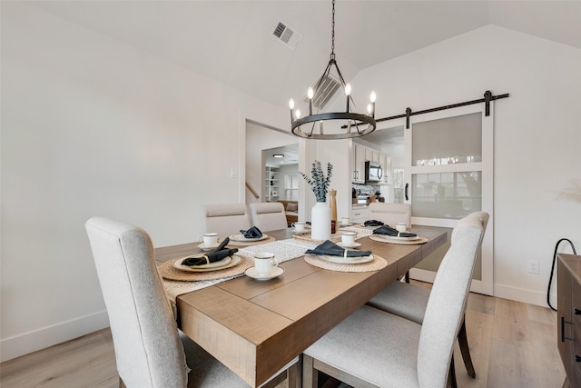 dining area with a chandelier, light wood-style floors, baseboards, visible vents, and lofted ceiling