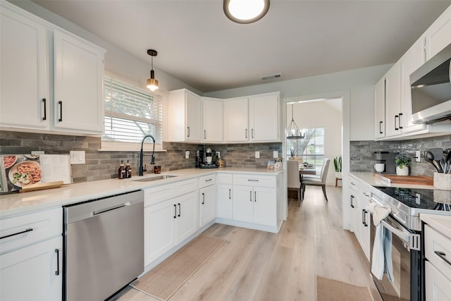 kitchen featuring a sink, appliances with stainless steel finishes, a wealth of natural light, and visible vents
