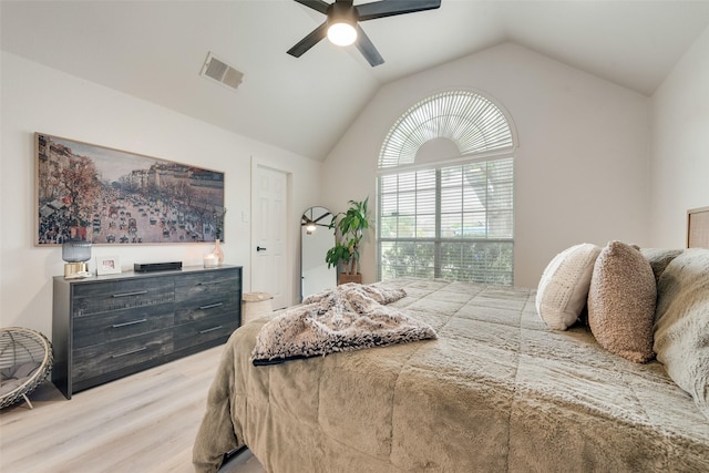 bedroom featuring light wood finished floors, a ceiling fan, visible vents, and lofted ceiling