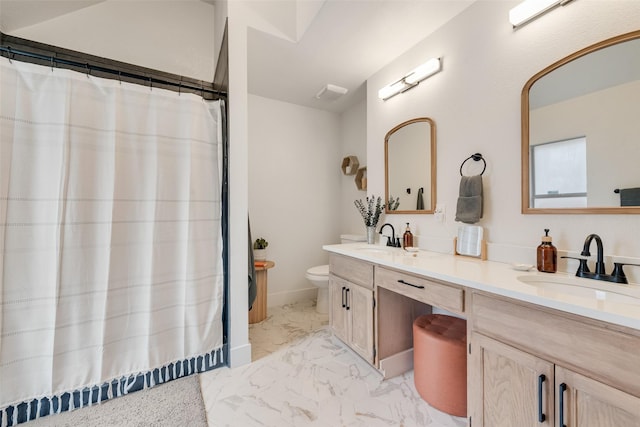 full bathroom featuring toilet, marble finish floor, a sink, and double vanity