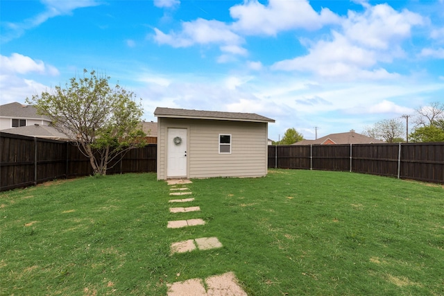 view of yard with an outdoor structure, a storage unit, and a fenced backyard