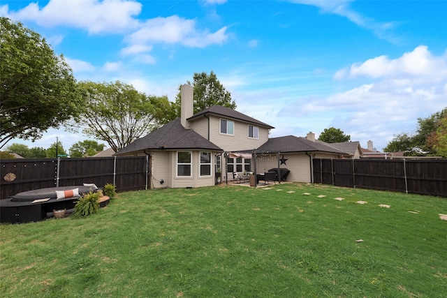back of house featuring a yard, a patio, and a fenced backyard