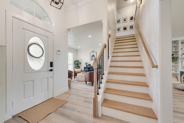 entrance foyer with stairway, wood finished floors, recessed lighting, and a towering ceiling
