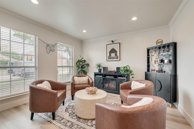 living area with ornamental molding, recessed lighting, light wood-style flooring, and baseboards