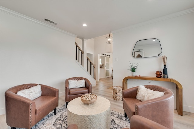 living area featuring light wood-style floors, visible vents, baseboards, ornamental molding, and stairs