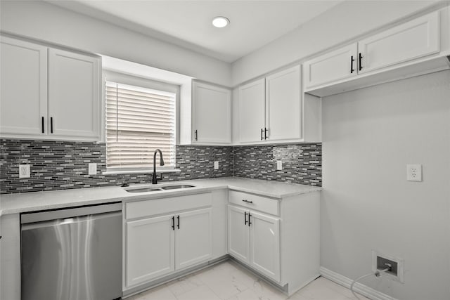 kitchen with stainless steel dishwasher, marble finish floor, light countertops, white cabinetry, and a sink