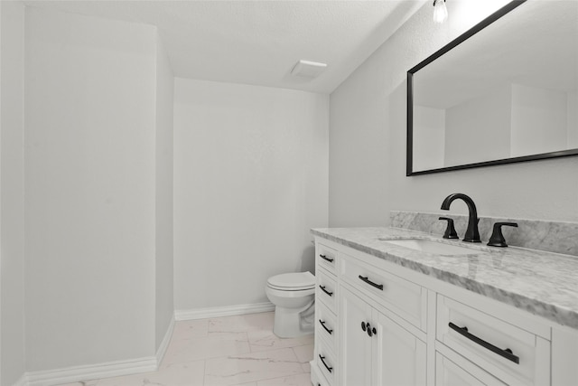 bathroom with vanity, baseboards, toilet, and marble finish floor