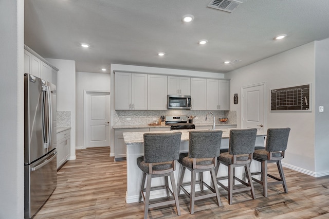 1409 Kirkdale Dr, Melissa, TX 75454 - kitchen featuring appliances with stainless steel finishes, backsplash, and light wood-style flooring