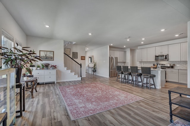 1409 Kirkdale Dr, Melissa, TX 75454 - living area featuring recessed lighting, light wood finished floors, baseboards, and stairway