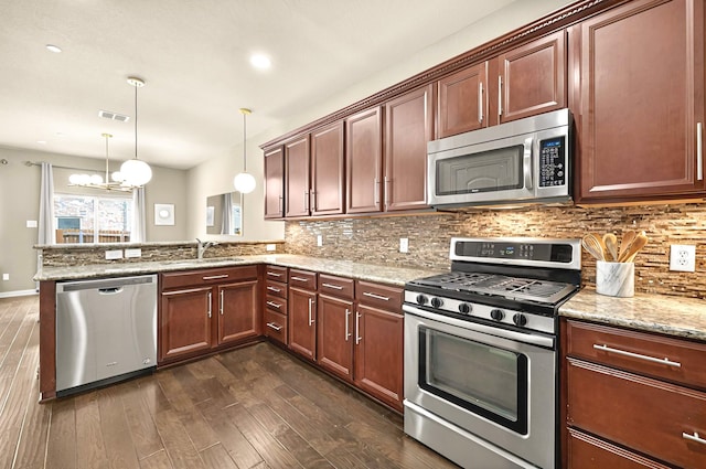 kitchen with appliances with stainless steel finishes, dark wood-style flooring, a sink, visible vents, and a peninsula