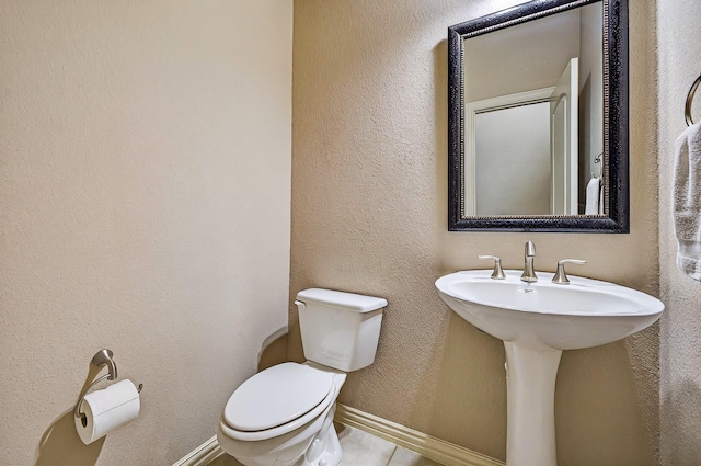 bathroom featuring toilet and baseboards