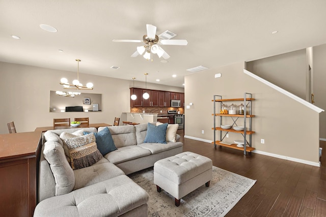 living area with recessed lighting, baseboards, dark wood finished floors, and ceiling fan with notable chandelier