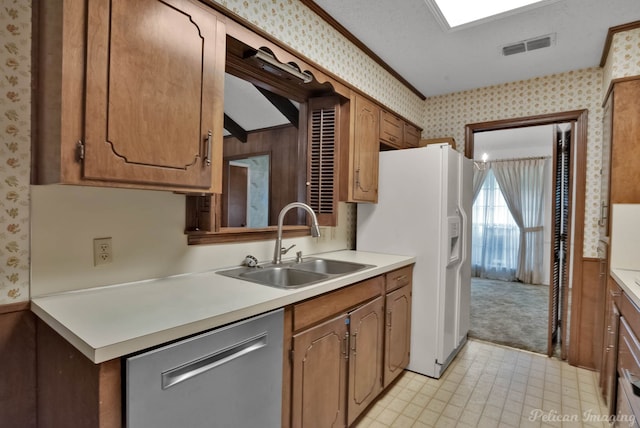 kitchen with white fridge with ice dispenser, stainless steel dishwasher, wallpapered walls, and a sink