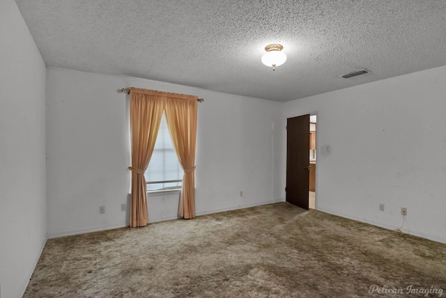 carpeted empty room with a textured ceiling and visible vents
