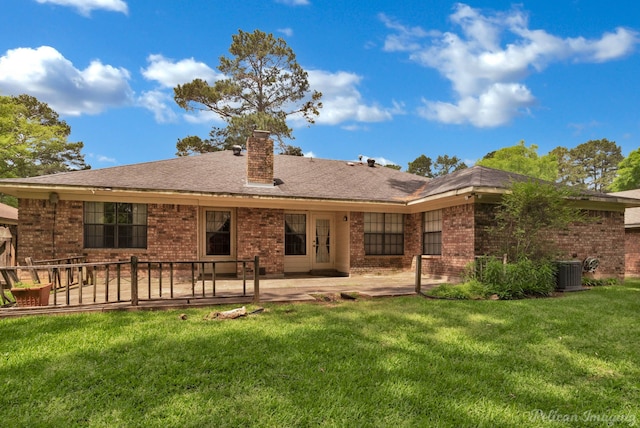 rear view of property with a patio area, a yard, a chimney, cooling unit, and brick siding