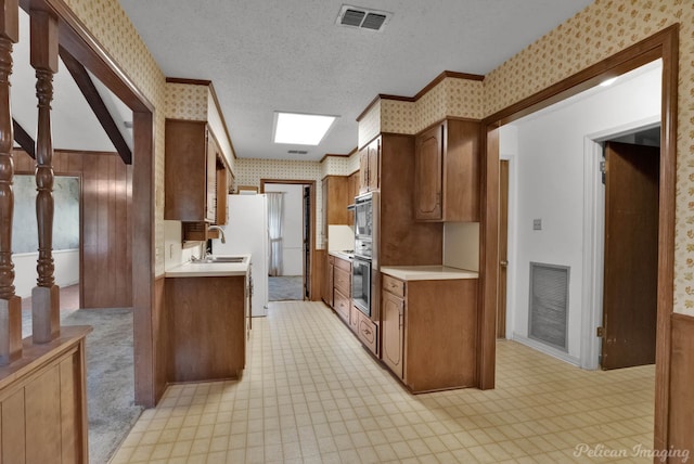 kitchen featuring visible vents, wallpapered walls, light floors, and light countertops