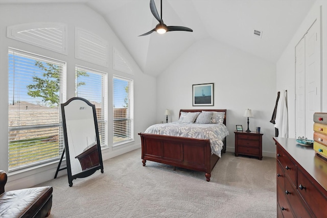 bedroom featuring visible vents, light carpet, vaulted ceiling, and multiple windows
