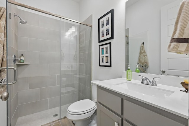 full bath with toilet, vanity, and a shower stall