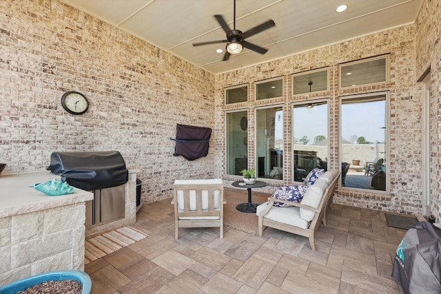 view of patio / terrace featuring area for grilling, a ceiling fan, and an outdoor kitchen
