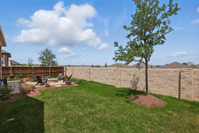 view of yard with a fire pit, a fenced backyard, and a patio area