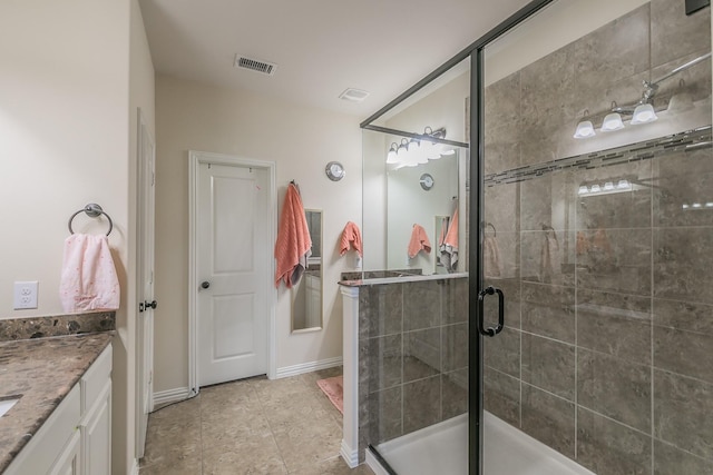 full bath featuring tile patterned flooring, vanity, baseboards, visible vents, and a stall shower
