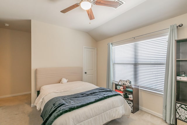 bedroom with ceiling fan, vaulted ceiling, light carpet, and baseboards