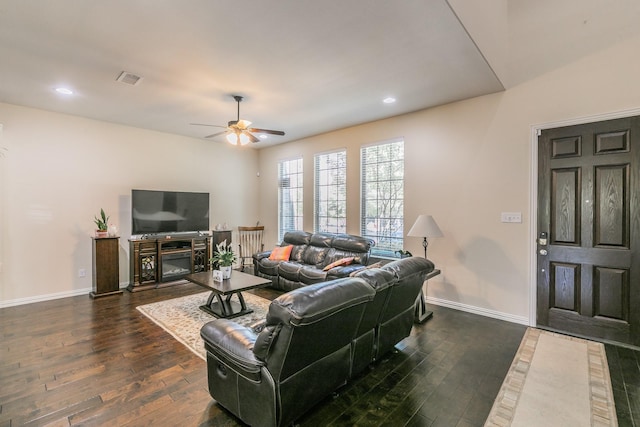 living area featuring visible vents, a ceiling fan, dark wood-style floors, and baseboards