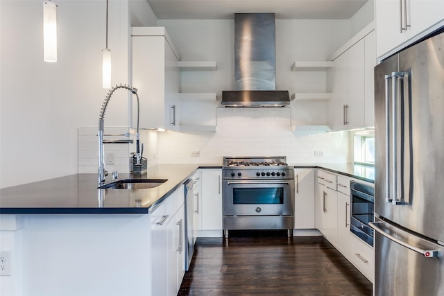 kitchen featuring a peninsula, open shelves, a sink, premium appliances, and wall chimney exhaust hood