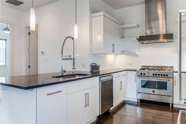 kitchen with a sink, stainless steel appliances, open shelves, a peninsula, and wall chimney range hood