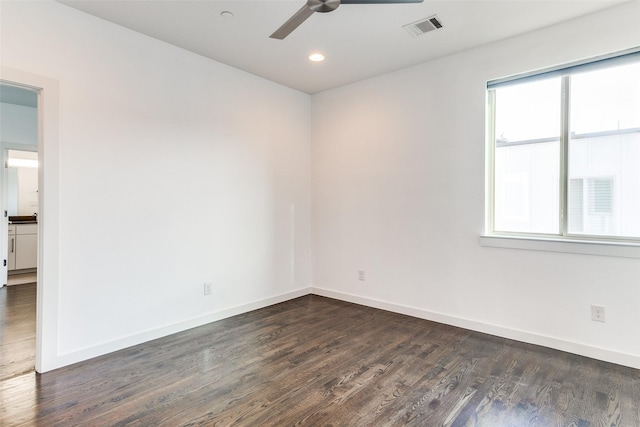 unfurnished room featuring baseboards, visible vents, ceiling fan, and dark wood-type flooring
