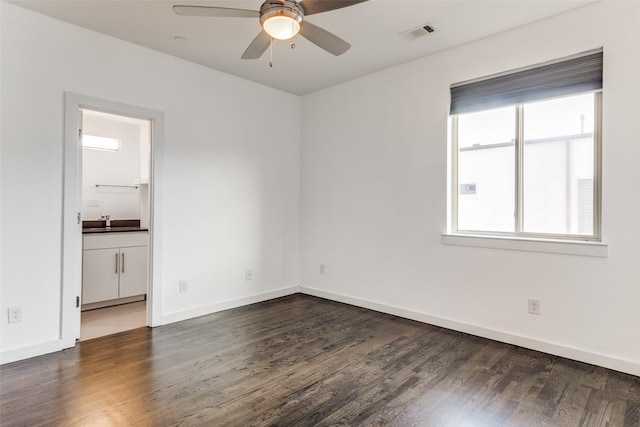 spare room with a sink, visible vents, ceiling fan, baseboards, and wood finished floors