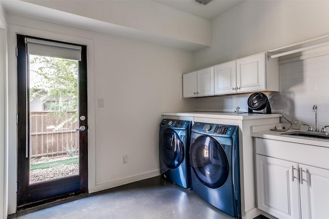 clothes washing area featuring a sink, cabinet space, separate washer and dryer, visible vents, and baseboards