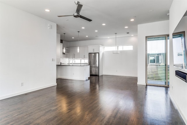 unfurnished living room with recessed lighting, a ceiling fan, baseboards, and dark wood-type flooring