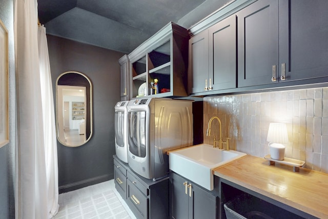 laundry area with separate washer and dryer, a sink, cabinet space, and baseboards